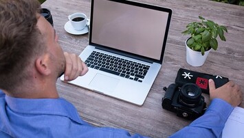 Man achter laptop