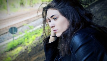 Vrouw kijkt bedenkelijk langs de camera