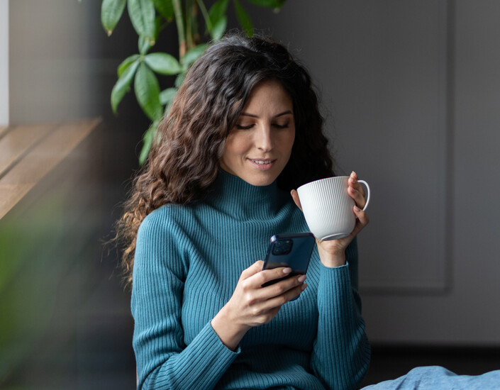 Een vrouw blijft op haar mobiel eenvoudig op de hoogte van actuele ontwikkelingen 	